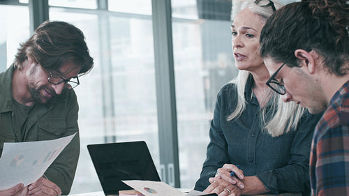 Senior businesswoman talking with colleagues smiling in meeting