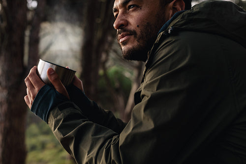 Hiker relaxing and having coffee outdoors