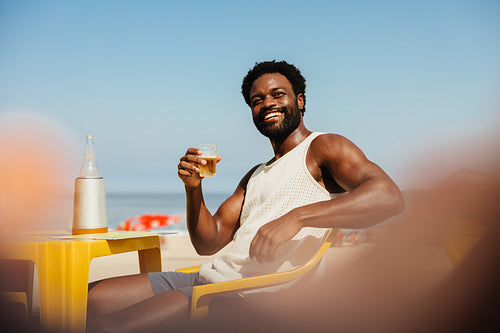 Carefree summertime vacation enjoying a drink by the beach