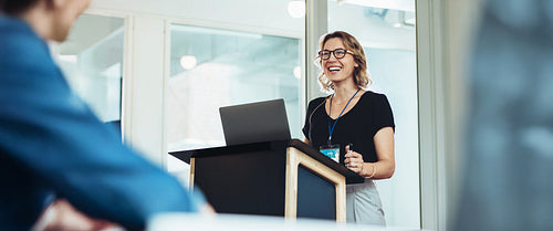 Confident woman leading presentation at business event