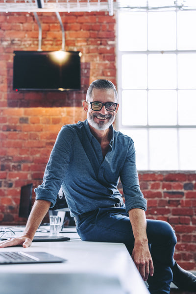 Experienced businessman smiling at the camera in an office