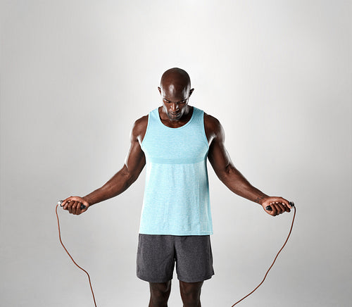 Portrait of masculine man skipping rope