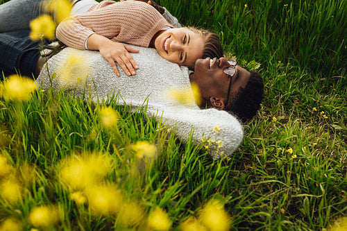Beautiful young couple lying in green grass