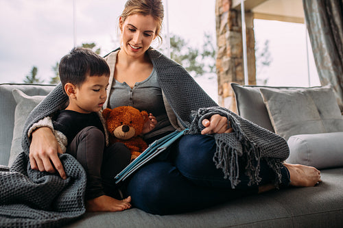 Mother and son using digital tablet in living room