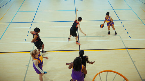 Young athletes playing basketball on indoor court
