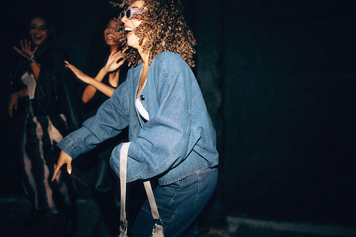 Group of friends dancing together at a night party with joyful energy