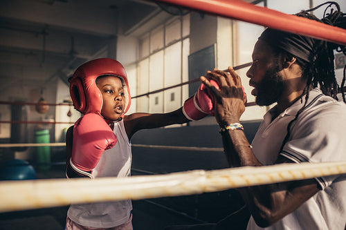 Boxing kid practicing punches with his coach
