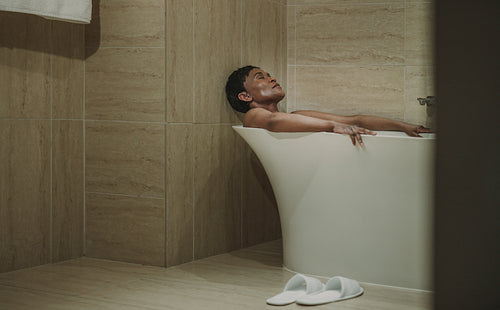 Mature african woman lying in bathtub