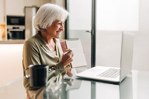 Happy senior businesswoman having a virtual meeting at home