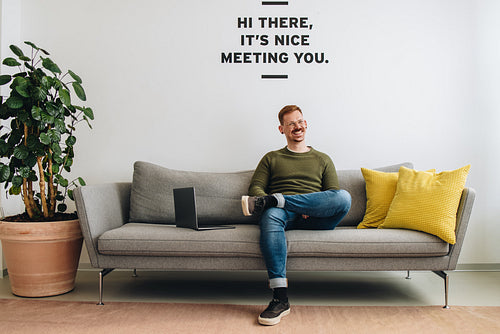 Cheerful businessman sitting relaxed at office lobby