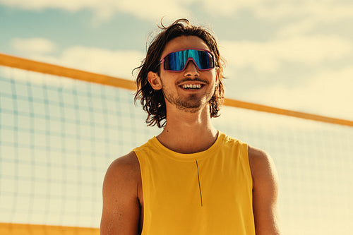 Happy australian athlete playing beach volleyball under clear skies