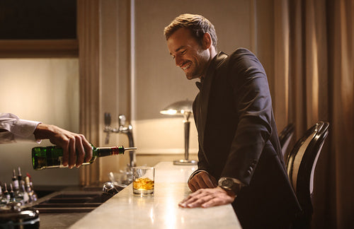 Bartender serving drink to a man at nightclub
