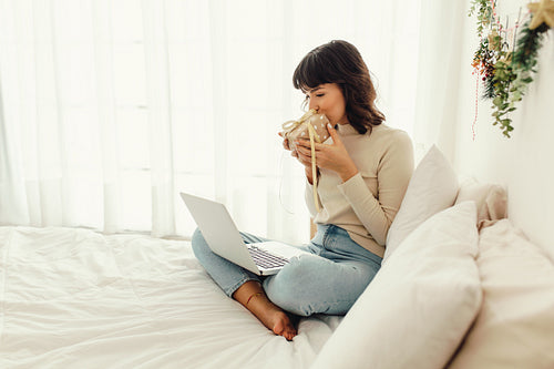 Woman kissing her christmas gift on a video call