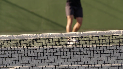 Tennis player practicing forehands on hard court