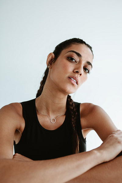 Fitness woman sitting against white background