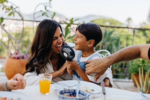 Mother and son sharing a joyful moment during an outdoor family meal