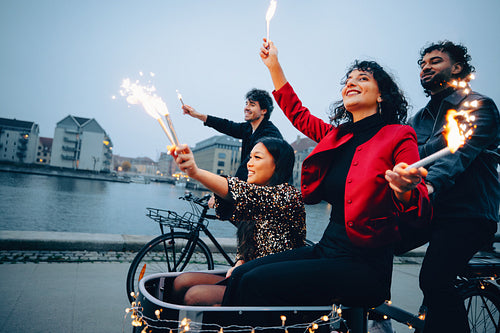 Friends celebrating with sparklers during an evening city outing near the canals
