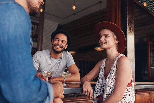 Group of young friends sitting and talking at a cafe