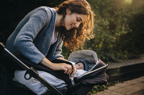 Mom taking his baby outdoors in a stroller