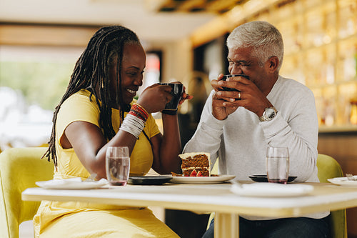Cheerful senior couple having coffee together in a cafe