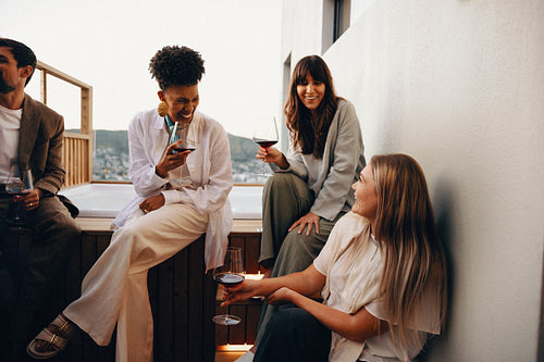 Friends enjoying wine and conversation on a modern rooftop terrace