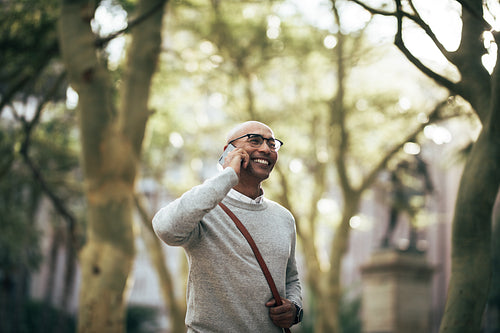 Businessman talking over mobile phone while commuting to office