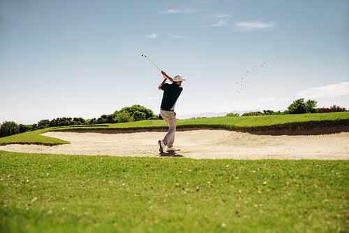 Male golfer in a stance showcasing a powerful swing