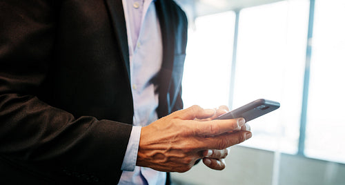 Businessman using his mobile phone indoor