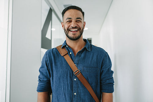 Happy young man in office corridor