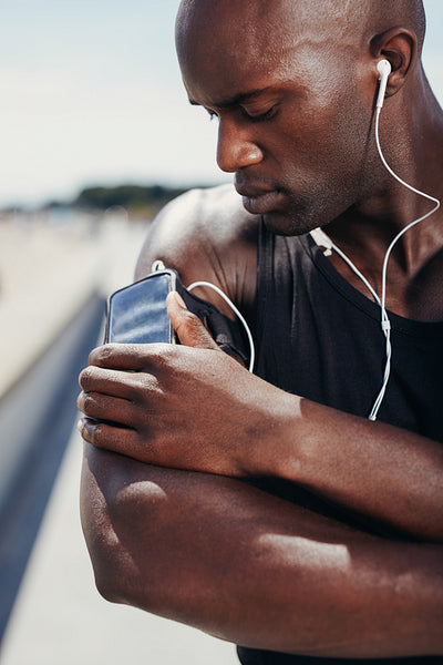African muscular athlete listening to music