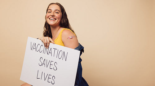 Pretty woman with "Vaccination saves lives" banner
