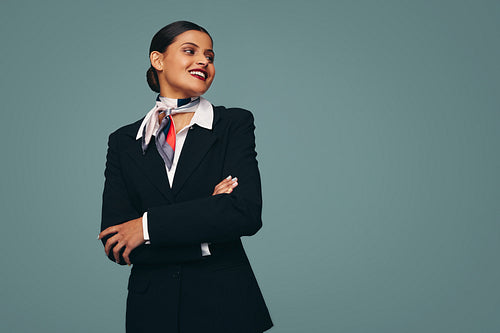 Cheerful stewardess smiling happily in a studio