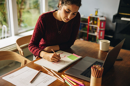 Woman illustrator drawing on paper