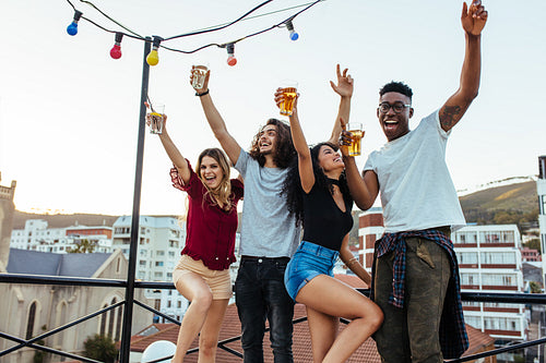 Group of happy friends having party on rooftop