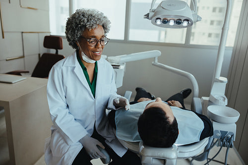 Senior patient having dental consultation with friendly dentist in modern clinic