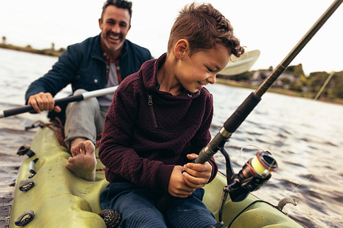 Father and son enjoying fishing in the lake