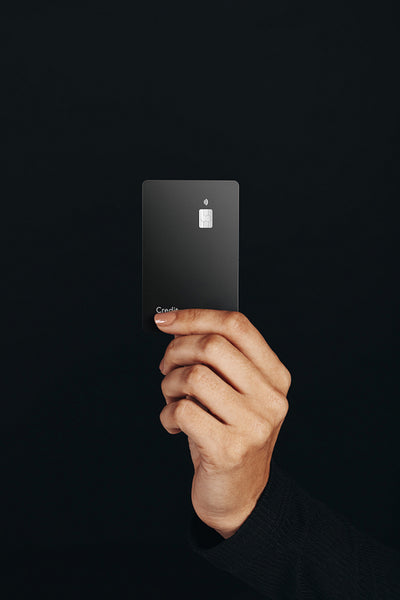 Premium banking with a contactless card: Hand holding a black credit card in a studio