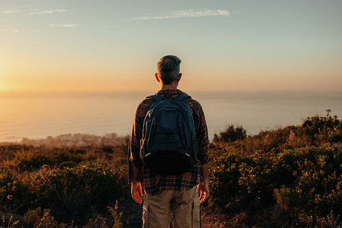 Unrecognisable backpacker looking at the view on a hilltop