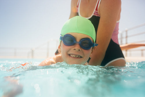 Boy learning to swim in a pool