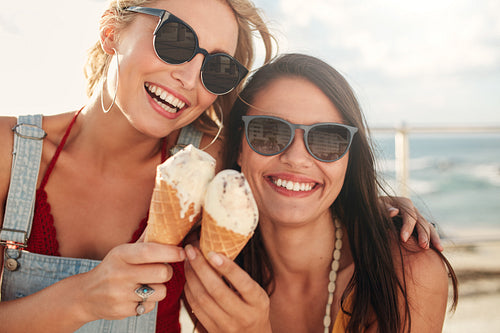 Two young friends having ice cream outside