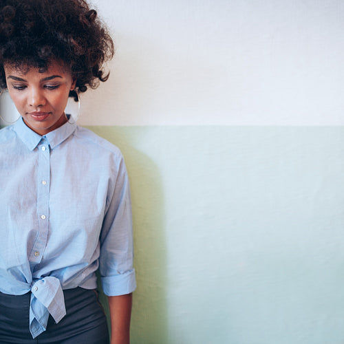 Beautiful young african woman standing against a wall