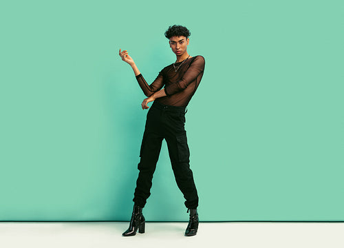 Gender fluid man with women’s clothing posing at studio