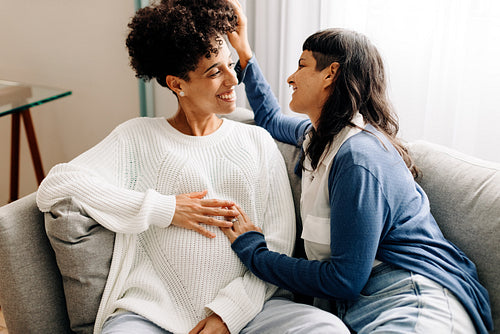 Queer parents-to-be sitting together at home
