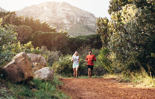 Athletic couple running together in a park