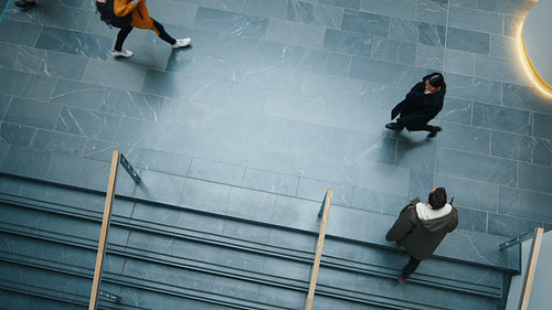 Busy day at the office: View from above of working professionals in motion