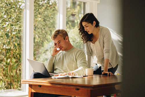 Concerned couple looking at laptop together