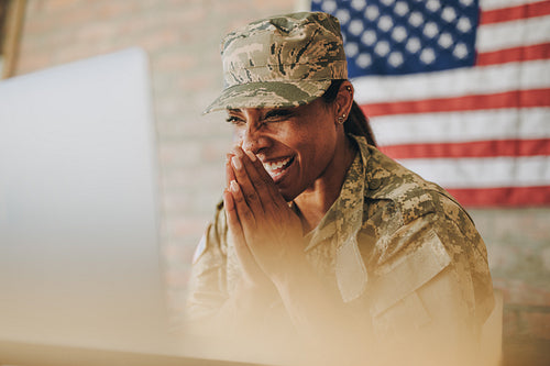 Happy servicewoman video calling her family on a laptop