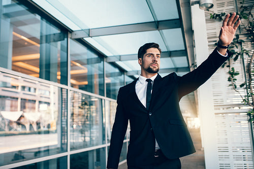 Young businessman calling taxi at the airport