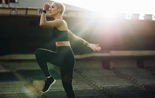 Female athlete doing warm up exercises in a stadium