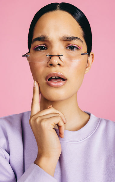 Young woman with eyeglasses on looks at the camera with an inquisitive expression